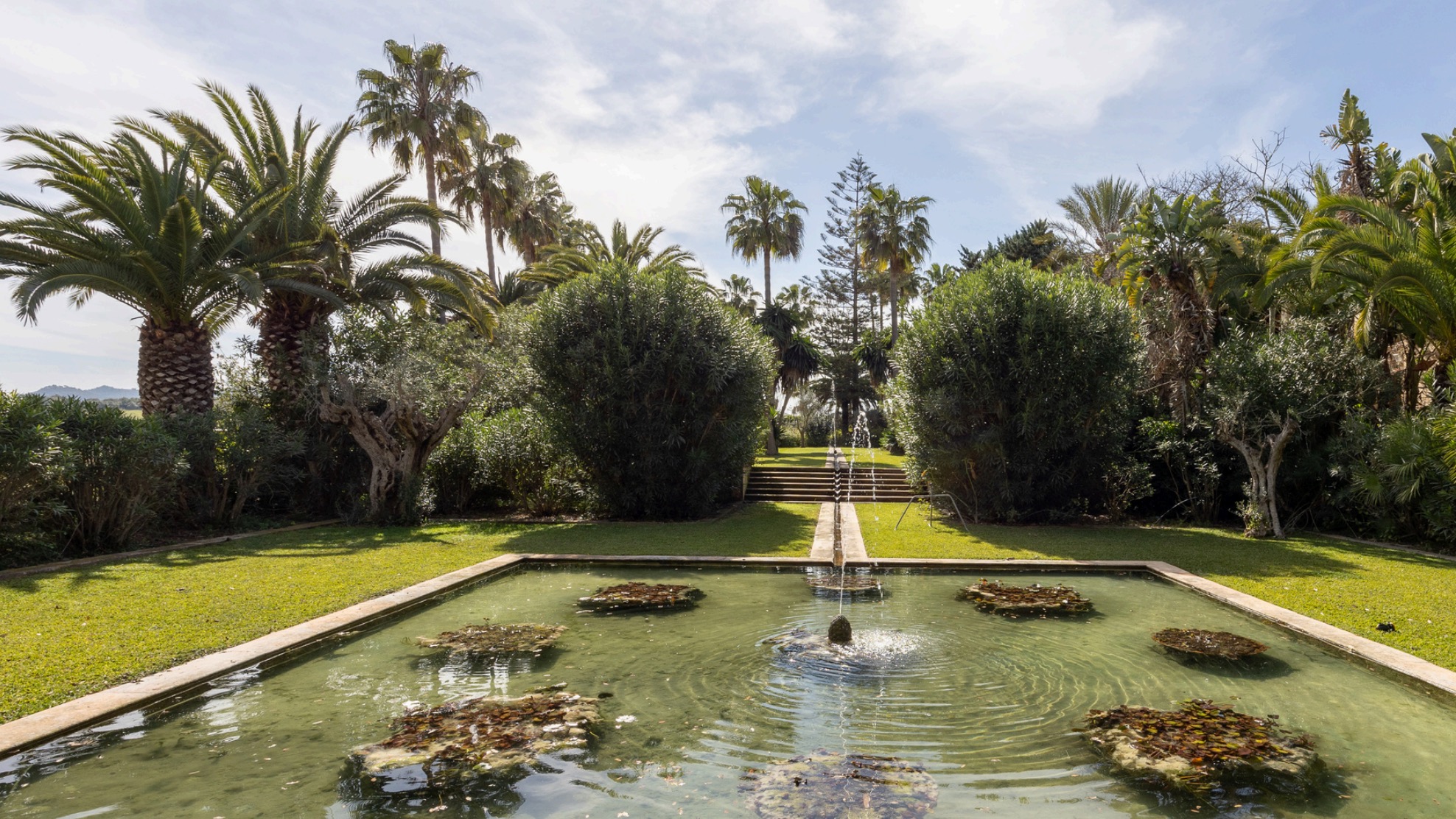 Son Cresp&iacute; — jard&iacute;n con estanque y palmeras
